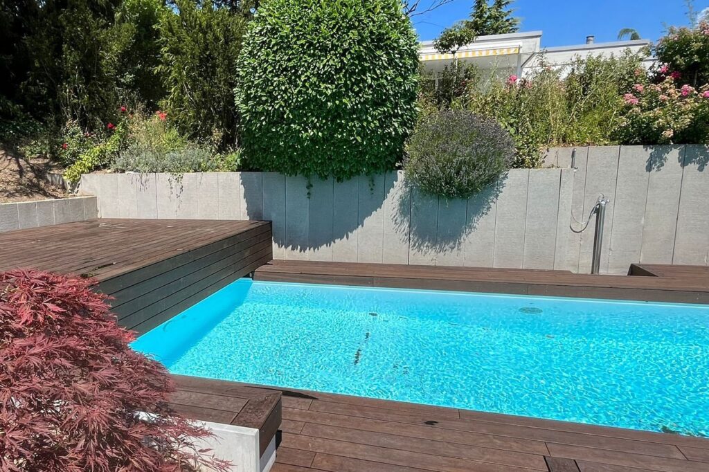 Dunkle Bambus-Terrassendielen als Poolumrandung im Garten
